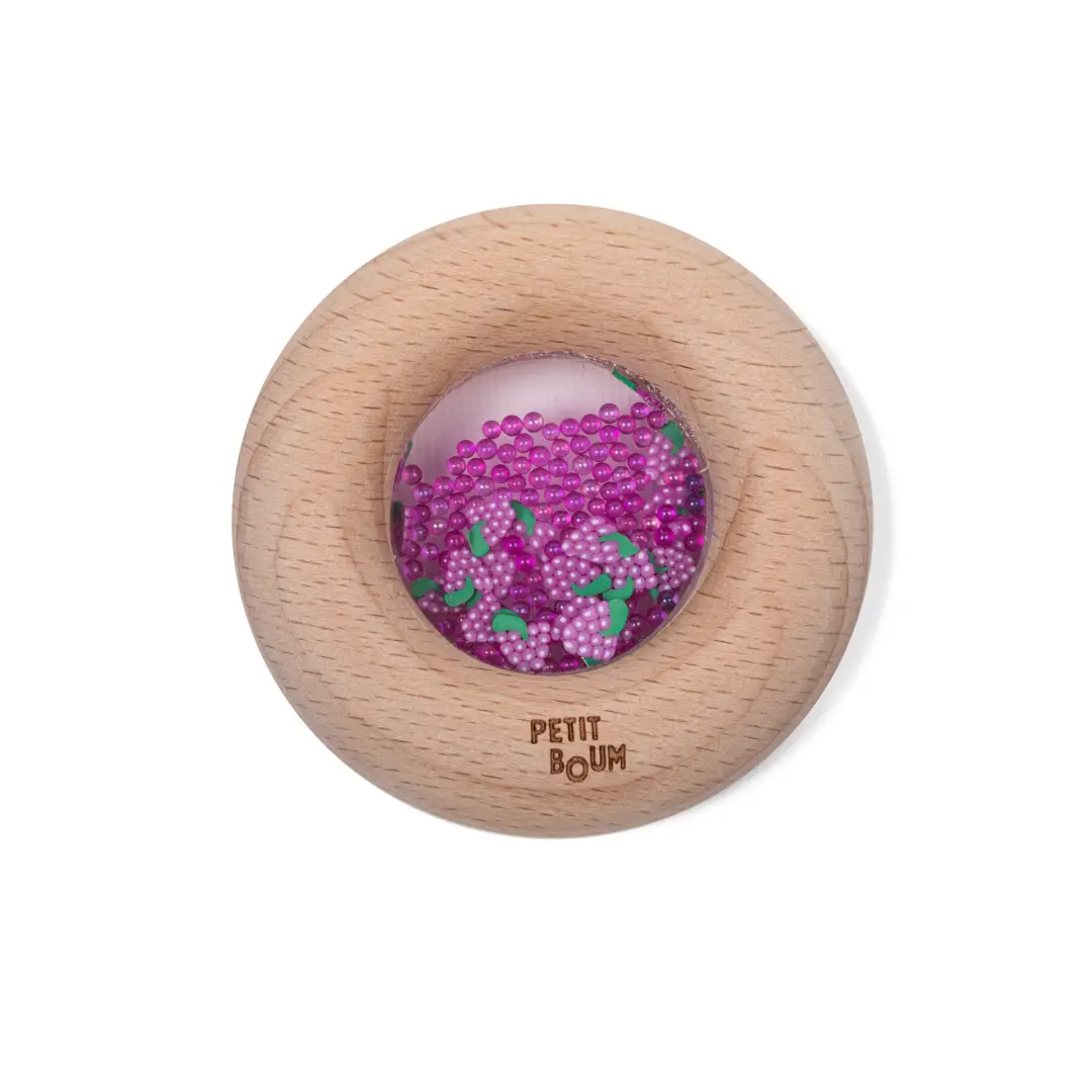 Sonajero sensorial donut uvas para estimular el oído y la vista, ideal para primeras exploraciones. Petit Boum en Mimú